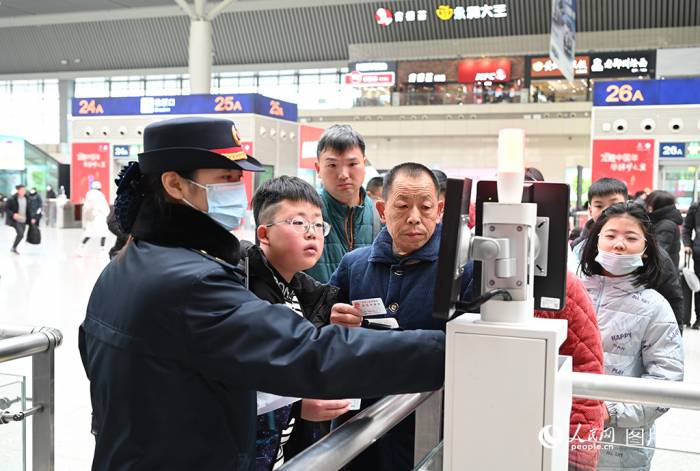 1月26日，春运首日，高铁郑州东站候车厅，工作人员在人工检票通道查验旅客身份。郑州东站全天共开行旅客列车736趟，预计发送旅客14.2万人。人民网记者王玉兴摄