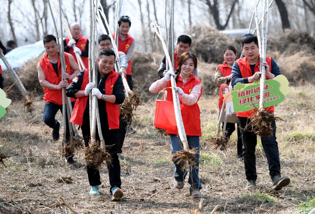 3月11日,山东省临沂市郯城县公益救援组织志愿者在马头镇白马河畔参加义务植树活动。新华社发(房德华摄)