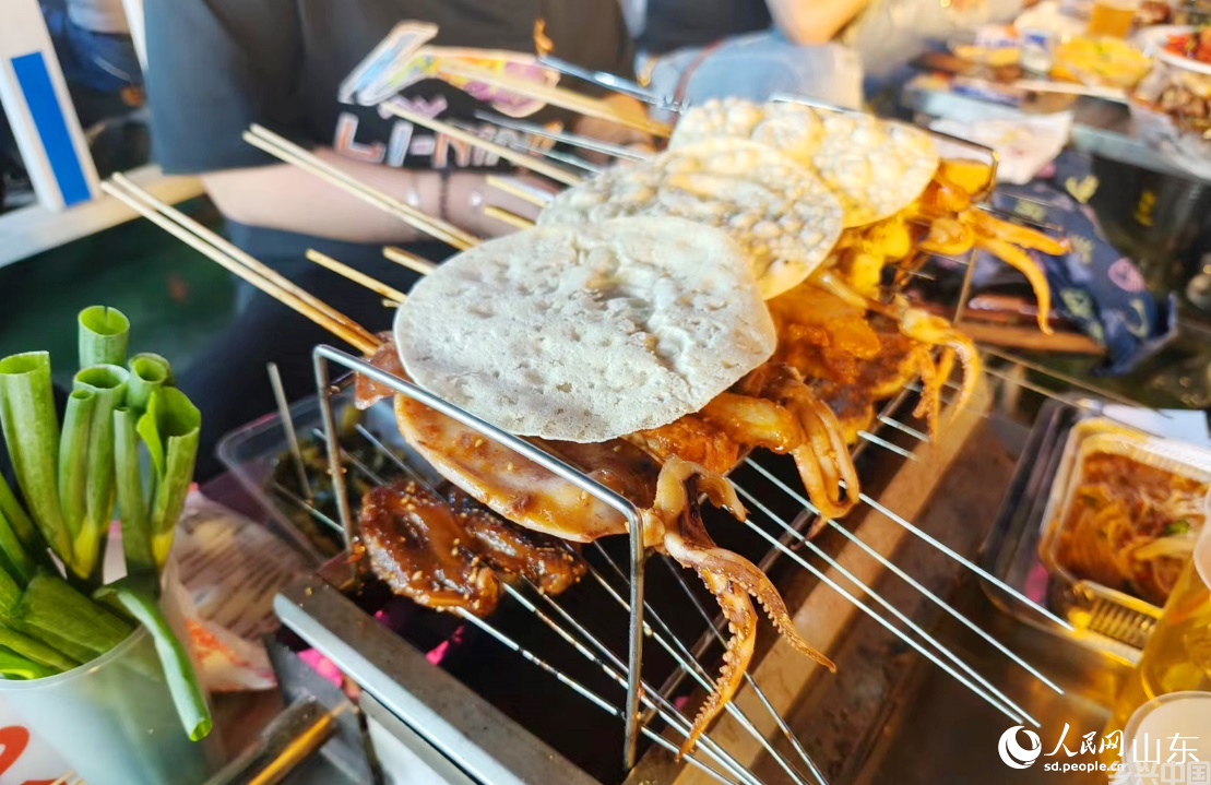 小饼卷上小葱和烤肉，让人欲罢不能。人民网记者 宋翠摄