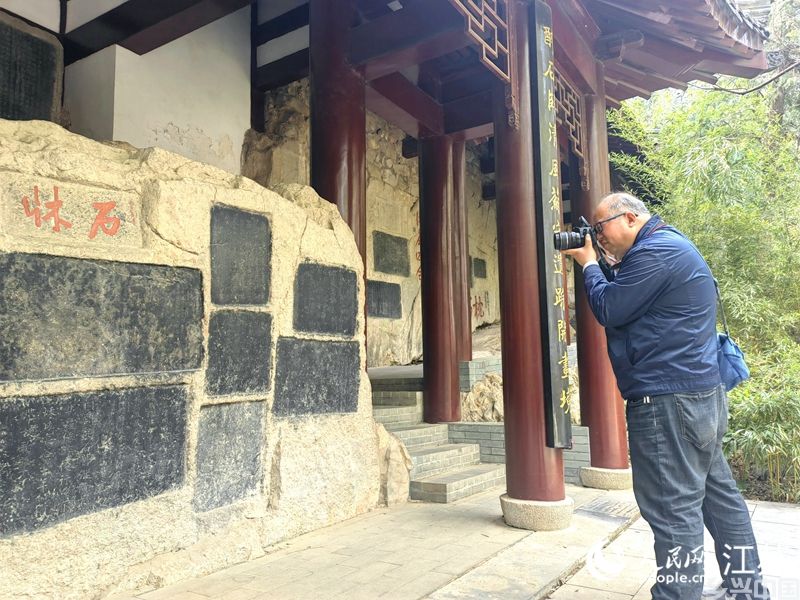陈钊在拍摄云龙山上的“东坡石床”。 人民网记者 张玉峰摄