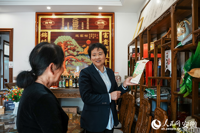 大湾村党总支书记何家枝向村民李定和了解农产品销售情况。人民网记者 王锐摄