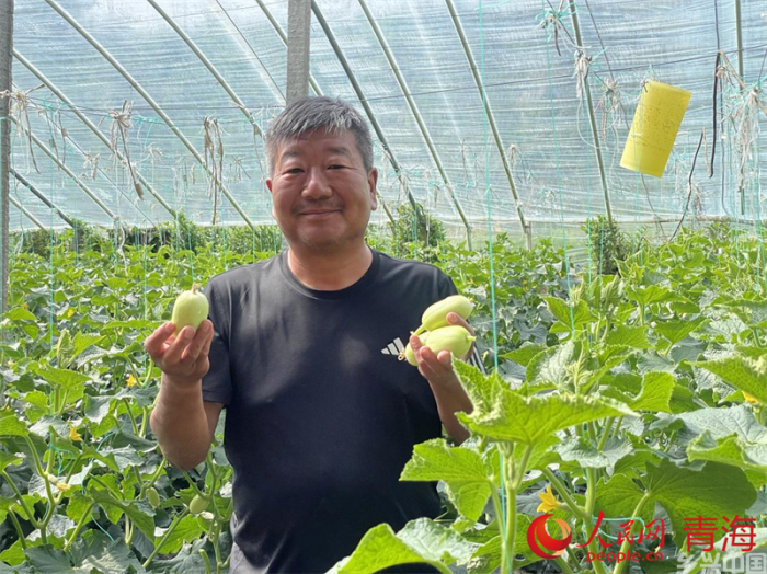 李希志展示新鲜采摘的水果。人民网 况玉摄