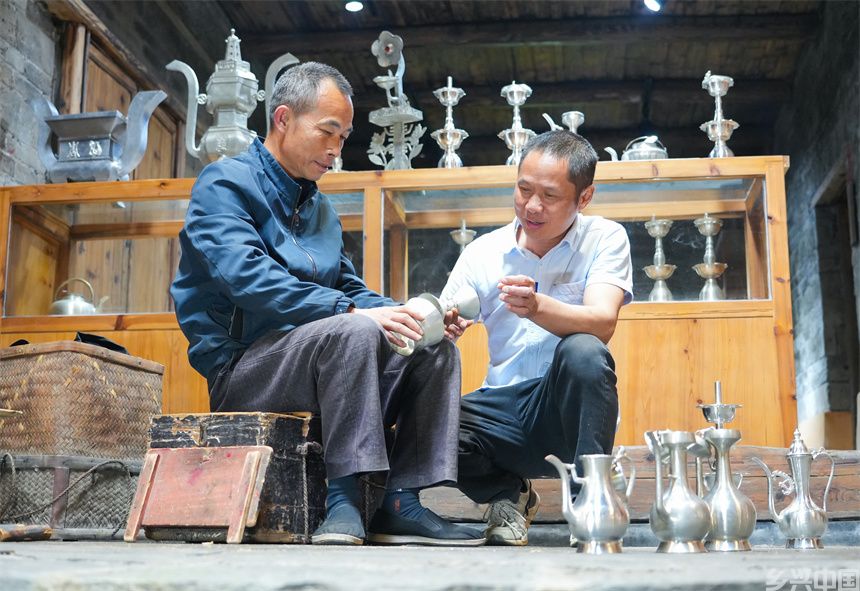 国家级非遗锡雕（莲花打锡）代表性传承人刘建强在与锡雕爱好者探讨制作工艺。人民网 孔文进摄