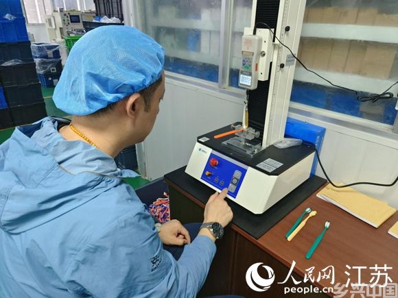 张德钢测试牙刷单丝压力。人民网 张瀚天摄
